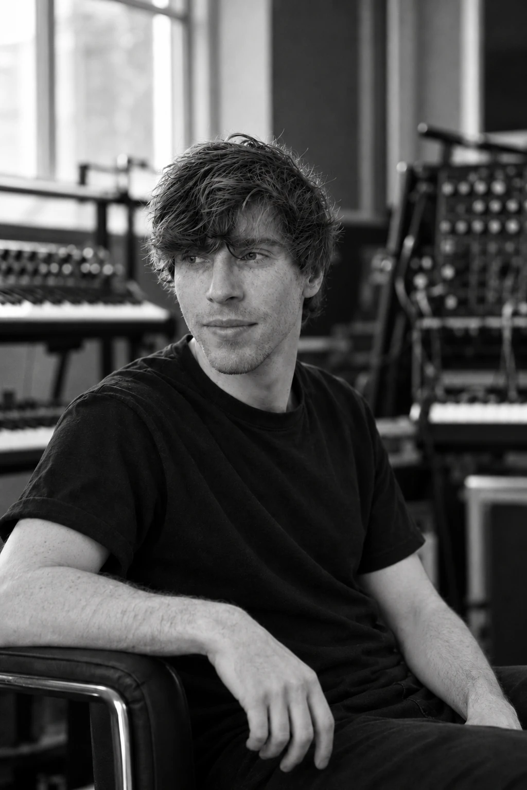 Black and white portrait of Sam Welch seated in a sound studio