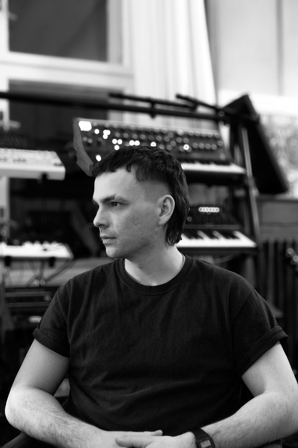 Stefan Janik in a studio surrounded by analogue synthesisers